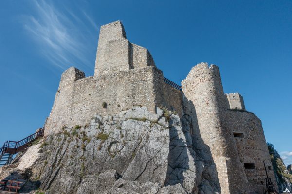 W dolnej części skała, na której wznoszą się kamienne mury górnego zamku. Po prawej stronie pozostałości półokrągłej wieży obronnej. Po lewej drewniane schody.